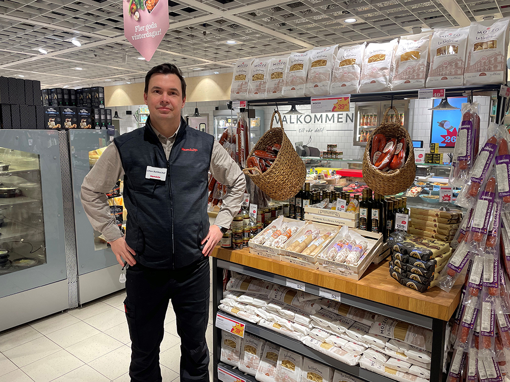 Linus Edestav står iklädd Hemköp-kläder i matbutiken Hemköp Mörby Centrum.