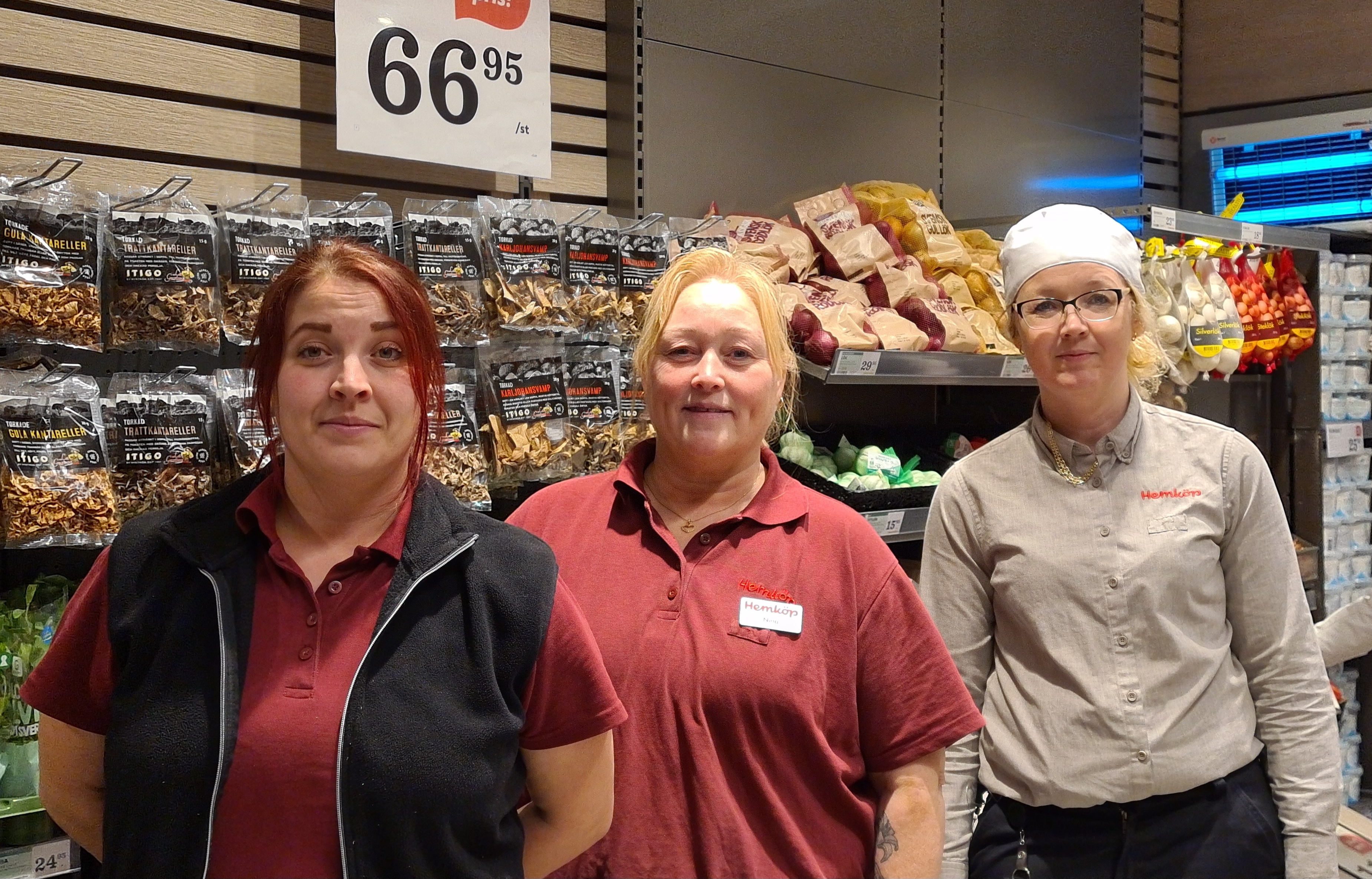 Tre glada kvinnliga medarbetare står vid fruktdisken i en Hemköpbutik i Hudiksvall